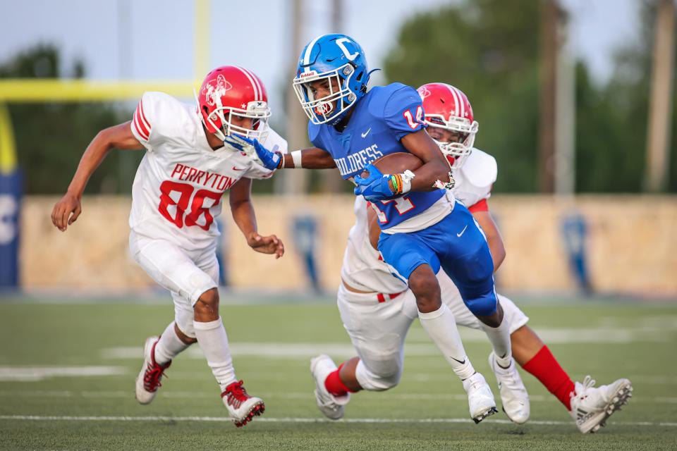 Childress' Lamont Nickleberry (14) takes the quick out pass and works to break free from the Ranger defenders during a nondistrict game Friday, Sept. 3, 2021, at Fair Park Stadium in Childress.