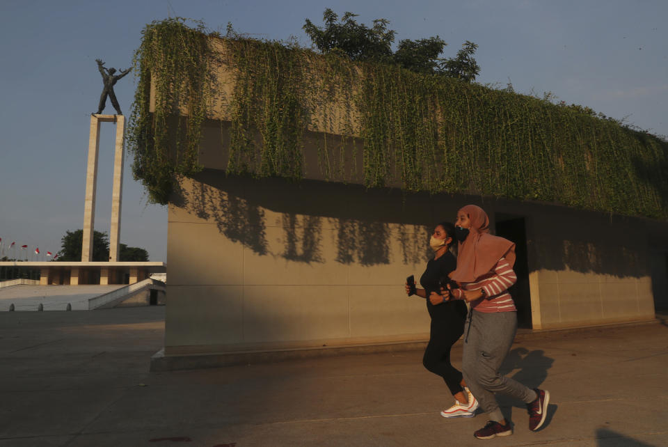 People wear face mask as a precaution against the coronavirus as they jog in Jakarta, Indonesia, Monday, Sept. 7, 2020. (AP Photo/Achmad Ibrahim)