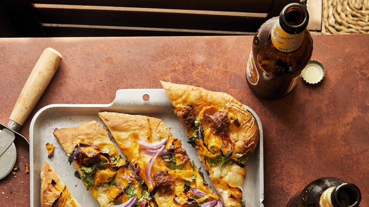 pumpkin chorizo pizza on a sheet pan and cut into slices