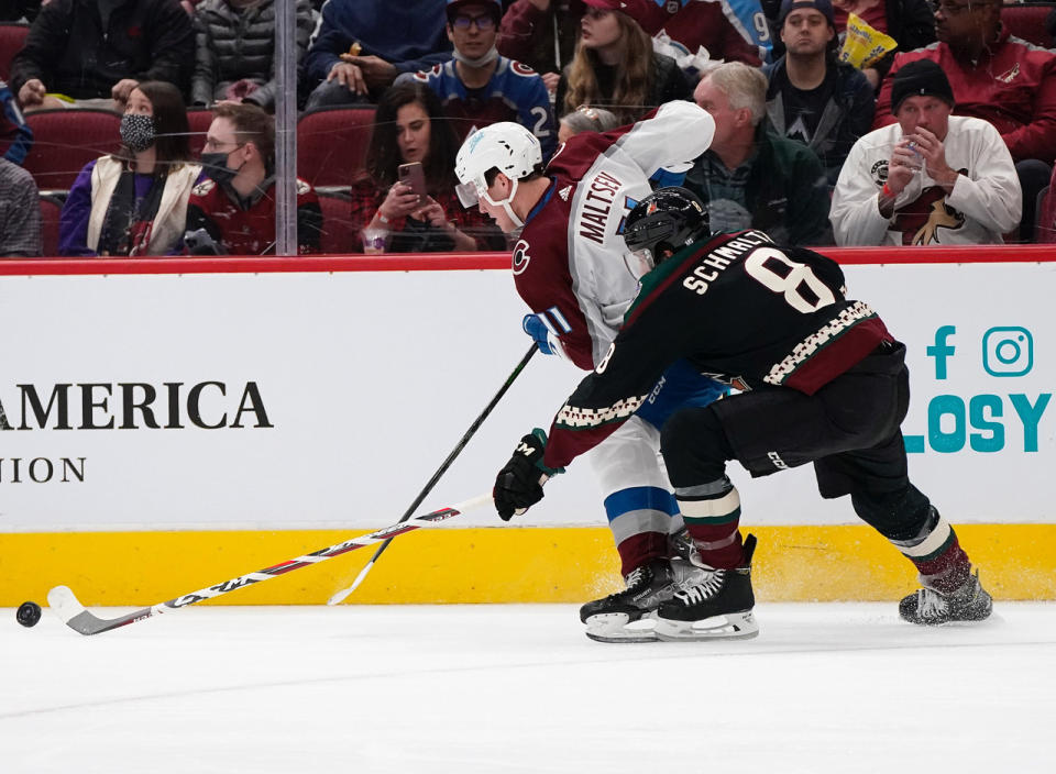 Colorado Avalanche's Mikhail Maltese (11) chases the puck with Arizona Coyotes' Nick Schmaltz (8) during the first period of an NHL hockey game Saturday, Jan. 15, 2022, in Glendale, Ariz. (AP Photo/Darryl Webb)