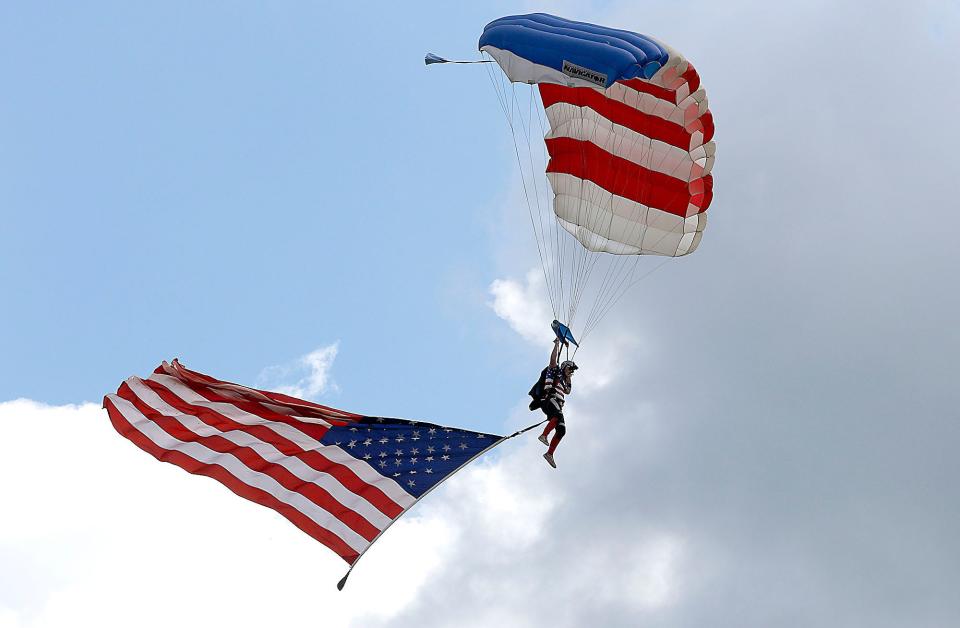 A skydiver from Aerohio lands with the American Flag during the opening ceremony of the ninth annual Ashland County Veterans Appreciation Day at the Ashland County Airport on Saturday, Aug. 6, 2022. TOM E. PUSKAR/ASHLAND TIMES-GAZETTE