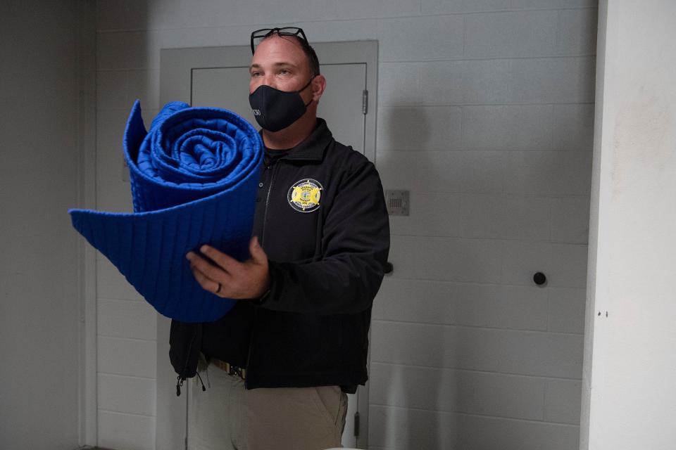 Buncombe County Sheriff's Capt. Jeffrey Littrell shows a blanket given to detainees on special watching during a jail tour Dec. 2, 2021.