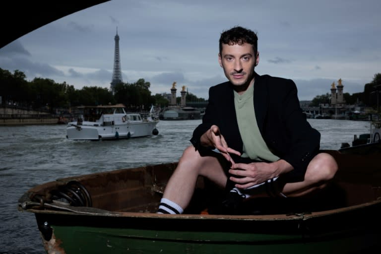 Thomas Jolly, director artístico de las ceremonia y clausura de los Juegos Olímpicos de París, posan en una barca en el río Sena, con la Torre Eiffel al fondo, el 2 de julio de 2024 en la capital francesa (Joel Saget)