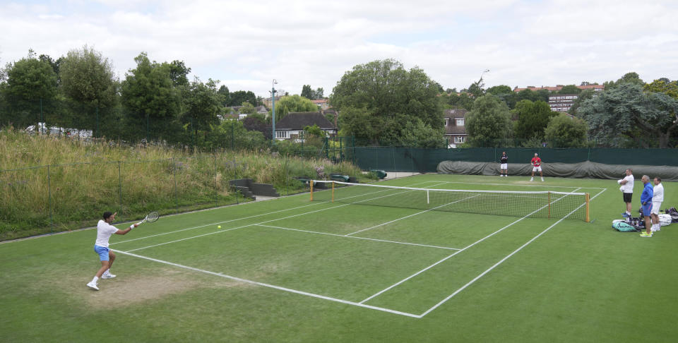 Novak Djokovic of Serbia, left, takes part in a practice session ahead of the Wimbledon tennis championships at Wimbledon, in London, Sunday, July 2, 2023. The Wimbledon Tennis championships start on July 3. (AP Photo/Kin Cheung)