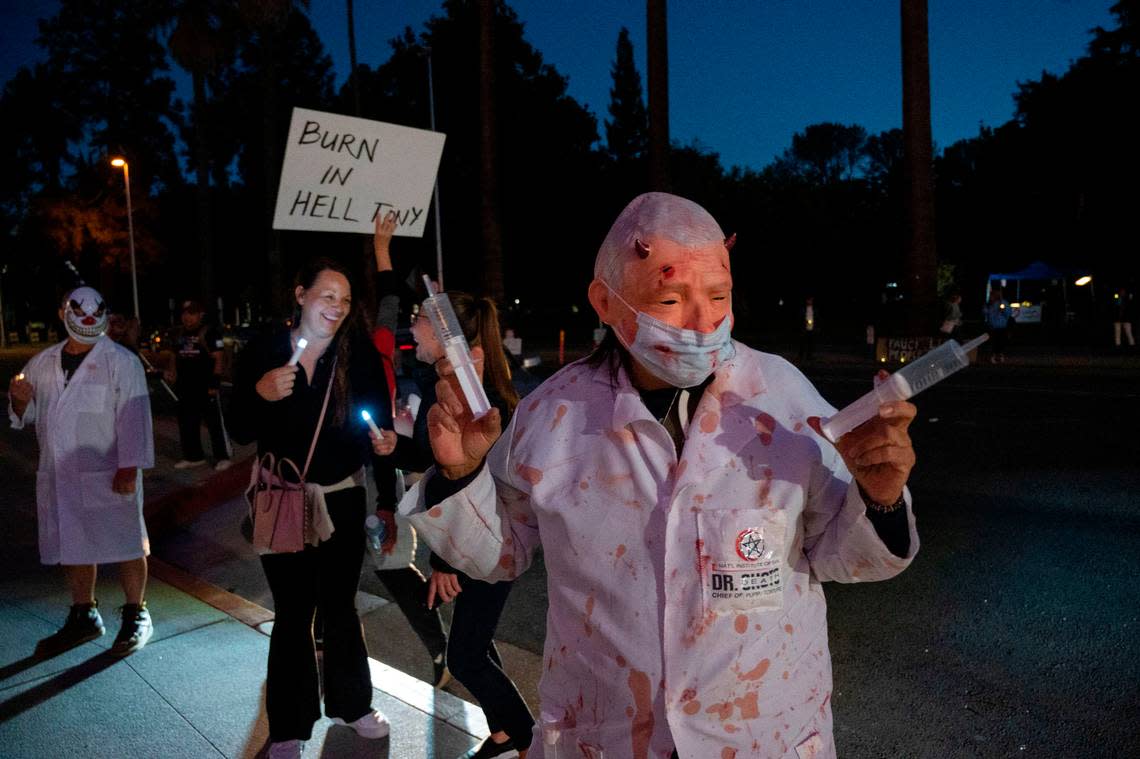 A group of people protest Dr. Anthony Fauci’s visit at the SAFE Credit Union Performing Arts Center on Wednesday, Oct. 11, 2023. Alicia Gonzalez, right, of Sacramento came dressed in a Fauci mask, equipped with over-sized syringes. The former chief medical advisor to the president was the featured guest in a local speaker series. Lezlie Sterling/lsterling@sacbee.com