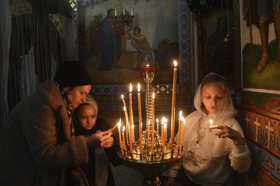 Orthodox believers light candles during a Christmas service in a church in Zhidkovichi, Gomel region, Belarus, Friday, Jan. 6, 2023. Orthodox Christians celebrate Christmas on Jan. 7, in accordance with the Julian calendar. (AP Photo)