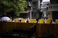 Residents wearing face masks line up for nucleic acid testings at a residential compound in Wuhan