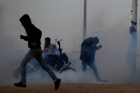 Palestinians react to tear gas fired by Israeli troops during a protest at the Israeli-Gaza border fence, east of Gaza City March 29, 2019. REUTERS/Mohammed Salem