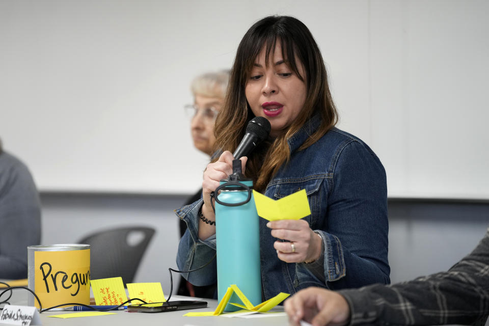 Fabiola Schirrmeister reads a question from an audience member during an Iowa Migrant Movement for Justice informational meeting, Wednesday, March 27, 2024, in Des Moines, Iowa. A bill in Iowa that would allow the state to arrest and deport some migrants is stoking anxiety among immigrant communities about how it would be interpreted and enforced. (AP Photo/Charlie Neibergall)