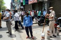 La police disperse des consommateurs qui faisaient la queue pour acheter de l'alcool, le 4 mai 2020 à New Dehli (Inde)