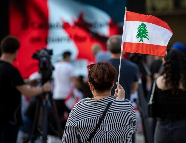 Hundreds lit candles, signed a board entitled 'letters for Beirut' and carried Lebanese flags in Nathan Phillips Square last summer as they remembered those who died in the explosion. They listened to speakers and held a moment of silence. (Evan Mitsui/CBC - image credit)