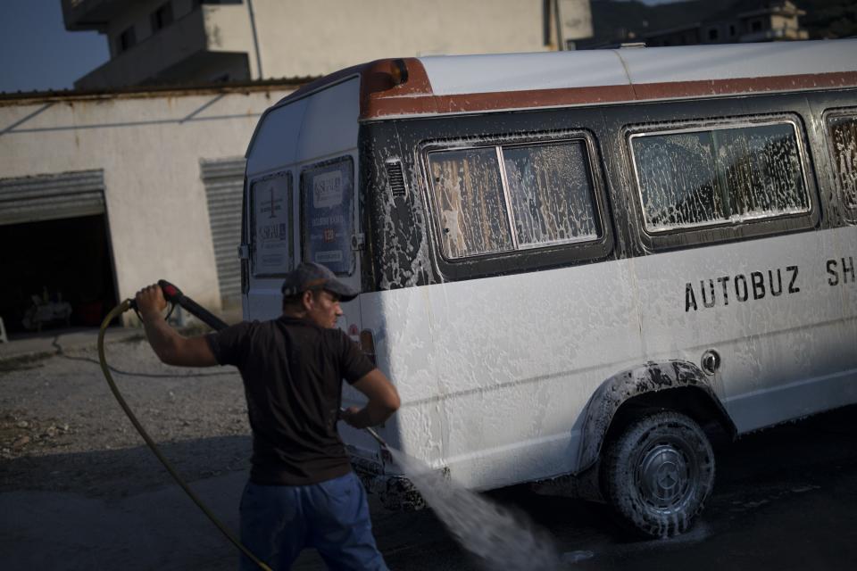 En la fotografía, un trabajador limpia un autobús escolar en un negocio de lavado de vehículos. (Foto: Daniel Cole / AP).