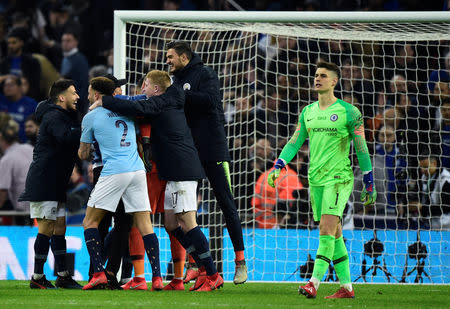 Soccer Football - Carabao Cup Final - Manchester City v Chelsea - Wembley Stadium, London, Britain - February 24, 2019 Chelsea's Kepa Arrizabalaga looks dejected as Manchester City players celebrate winning the penalty shootout REUTERS/Rebecca Naden