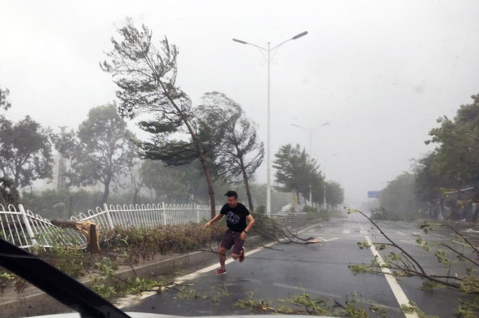 <p>A man runs in strong wind brought by typhoon Hato on Aug. 23, 2017 in Zhuhai, Guangdong Province of China. (Photo: VCG via Getty Images) </p>