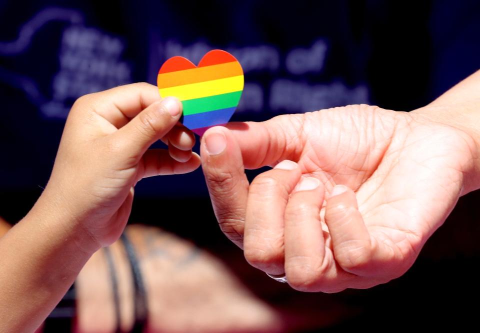 A PRIDE sticker is exchanged during a Westchester PRIDE event in downtown White Plains, N.Y., on June 5, 2022.