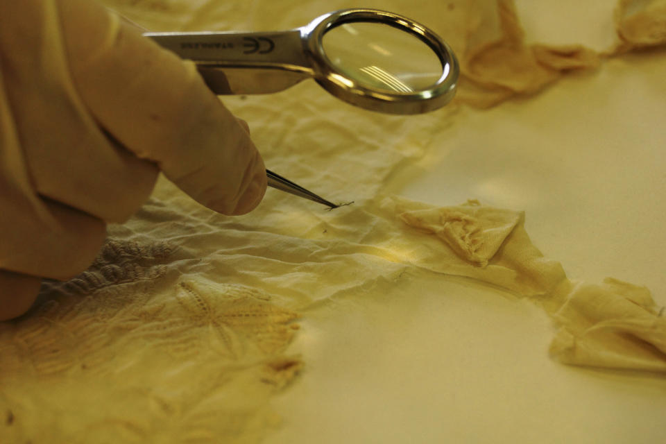 A specialist of the National Institute of Anthropology and History (INAH) inspects the shroud of Spanish conquistador Hernan Cortes after it was restored INAH specialists, in this July 30, 2014 INAH handout picture made available to Reuters November 24, 2014. The restoration of a white and black silk linen from the 18th century is part of the conservation project for the 70th anniversary of the National History Museum in Chapultepec Castle, according to a statement by the INAH. The Museum received in 1947 the linen with the skeletal remains of Cortes, who died in Castilleja de la Cuesta, Spain, on December 2, 1547 and whose remains were brought to Mexico in 1566. REUTERS/Manuel Curiel-INAH/Handout via Reuters (MEXICO - Tags: SOCIETY) ATTENTION EDITORS - THIS PICTURE WAS PROVIDED BY A THIRD PARTY. REUTERS IS UNABLE TO INDEPENDENTLY VERIFY THE AUTHENTICITY, CONTENT, LOCATION OR DATE OF THIS IMAGE. FOR EDITORIAL USE ONLY. NOT FOR SALE FOR MARKETING OR ADVERTISING CAMPAIGNS. THIS PICTURE IS DISTRIBUTED EXACTLY AS RECEIVED BY REUTERS, AS A SERVICE TO CLIENTS