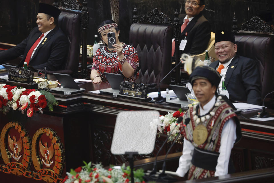 House Speaker Puan Maharani, second left, uses her mobile phone as Indonesian President Joko Widodo, wearing traditional attire from Tanimbar Islands of Maluku province, delivers his State of the Nation Address ahead of the country's Independence Day, at the parliament building in Jakarta, Indonesia, Wednesday, Aug. 16, 2023. (Willy Kurniawan/Pool Photo via AP)