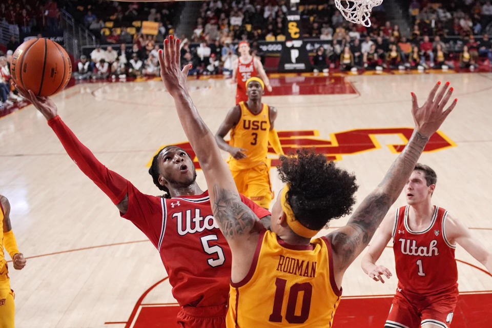 Utah guard Deivon Smith, left, shoots as Southern California forward DJ Rodman defends during the first half of an NCAA college basketball game Thursday, Feb. 15, 2024, in Los Angeles. (AP Photo/Mark J. Terrill)