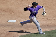 Colorado Rockies' Trevor Story throws out Chicago Cubs' Willson Contreras at first during the third inning of a spring training baseball game against the , Tuesday, Feb. 25, 2020, in Mesa, Ariz. (AP Photo/Matt York)