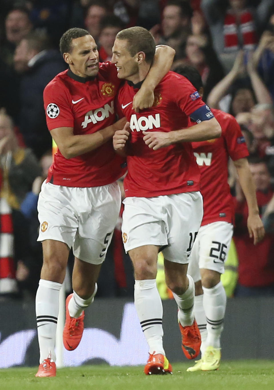 Manchester United's Rio Ferdinand, left, congratulates Nemanja Vidic after scoring the opening goal during the Champions League quarterfinal first leg soccer match between Manchester United and Bayern Munich at Old Trafford Stadium, Manchester, England, Tuesday, April 1, 2014.(AP Photo/Jon Super)