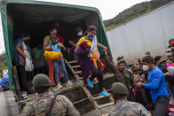 A Honduran migrant woman is helped off a Guatemalan army truck after being returned to El Florido, Guatemala, one of the border points between Guatemala and Honduras, Tuesday, Jan. 19, 2021. A once large caravan of Honduran migrants that pushed its way into Guatemala last week had dissipated by Tuesday in the face of Guatemalan security forces. (AP Photo/Oliver de Ros)