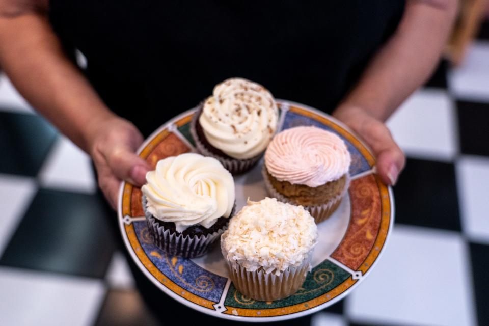 LynnRae Ries, founder and operations manager at Gluten-Free Creations Bakery, holds a plate of gluten-free cupcakes as she poses for a portrait inside the bakery in Phoenix on March 1, 2023.