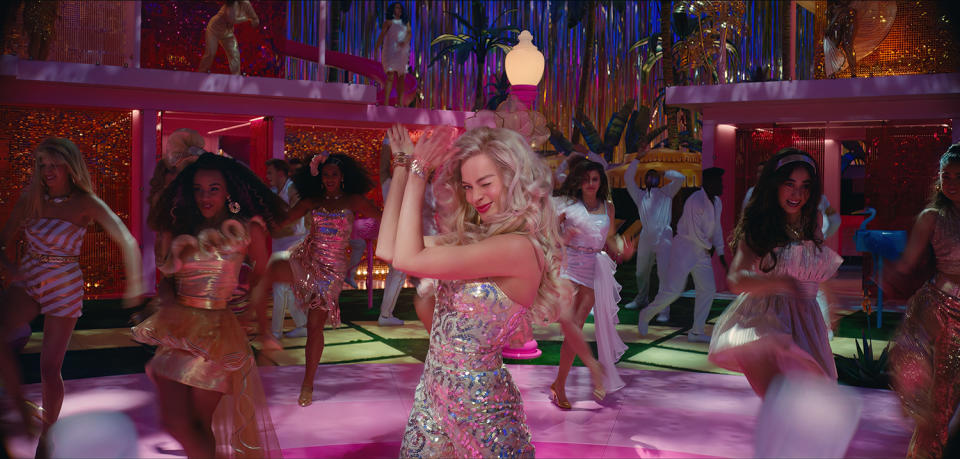 <p>In an official image from the film, Robbie is seen wearing a disco outfit as she dances with other Barbies in Barbieland. </p>