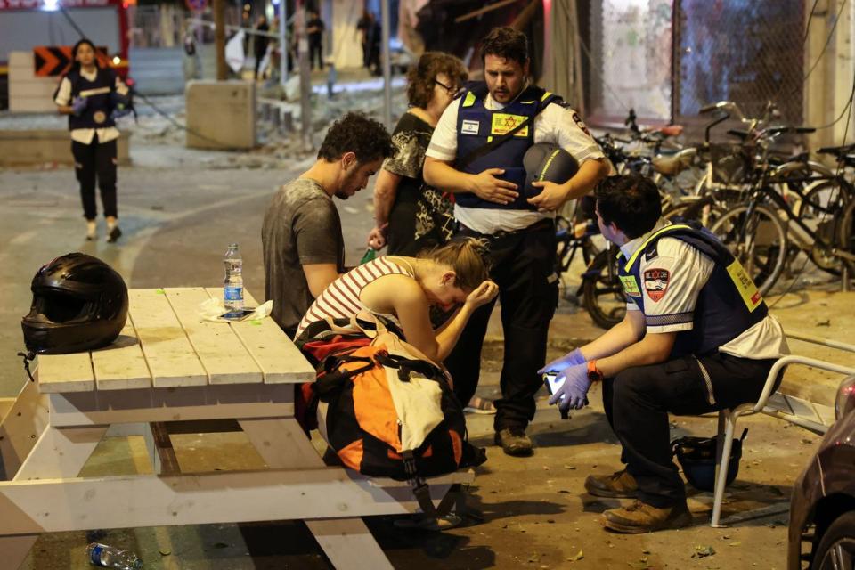 A young woman reacts as she speaks to Israeli rescuers in Tel Aviv, after the city was hit by rockets fired by Palestinian Hamas terrorists from the Gaza Strip on Oct. 7, 2023. (Jack Guez/AFP via Getty Images)