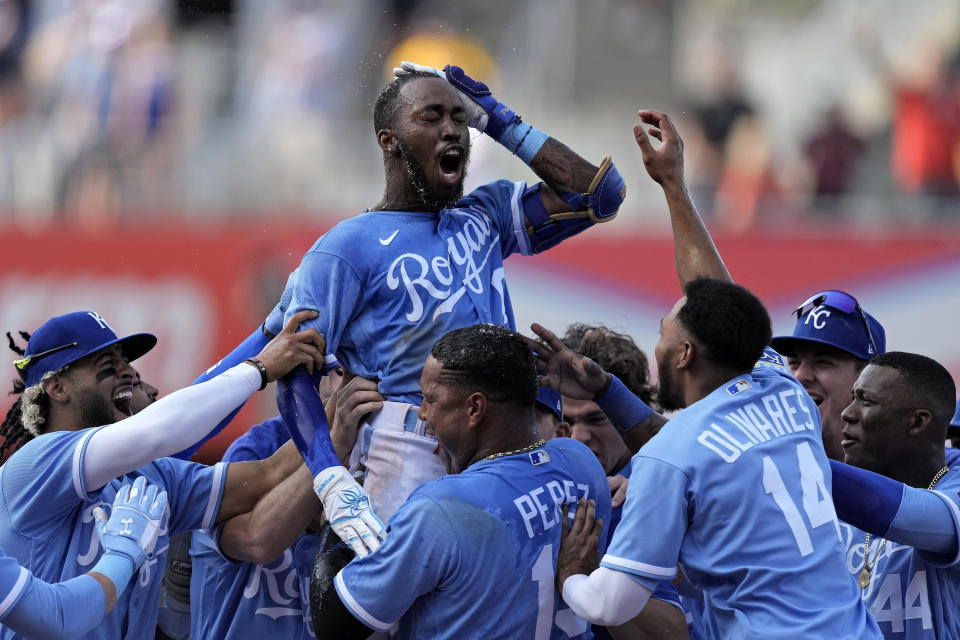 Kansas City Royals' Samad Taylor, center, celebrates with teammates after hitting a single to drive in the winning run during the ninth inning of a baseball game against the Los Angeles Angels Saturday, June 17, 2023, in Kansas City, Mo. The Royals won 10-9. (AP Photo/Charlie Riedel)