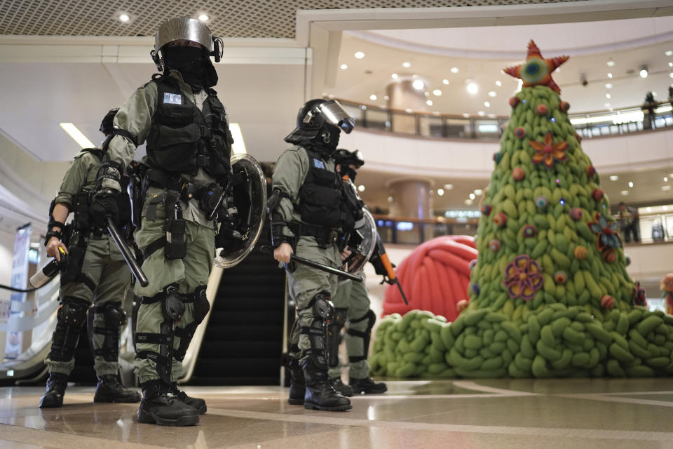 Riot police past by a Christmas decor in a mall during a protest rally on Christmas Eve in Hong Kong on Tuesday, Dec. 24, 2019. More than six months of protests have beset the city with frequent confrontations between protesters and police. (AP Photo/Kin Cheung)