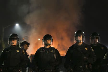 Police officers hold a line before advancing on protesters during the second night of demonstrations in Oakland, California, following the grand jury decision in the shooting of Michael Brown in Ferguson, Missouri, November 25, 2014. REUTERS/Elijah Nouvelage