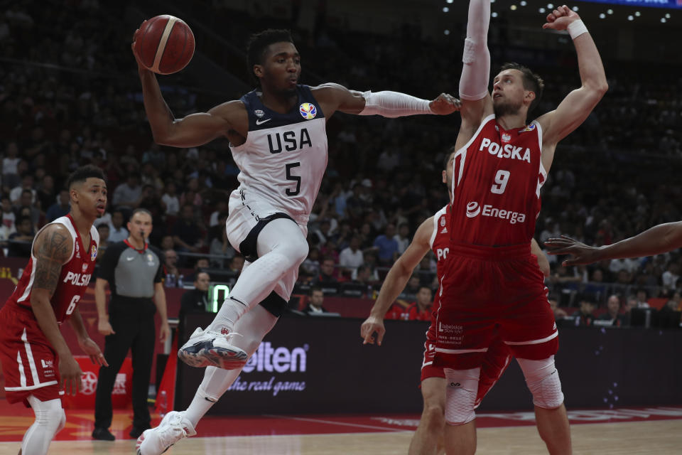 United States' Donovan Mitchell attempts to pass the ball near Poland's Mateusz Ponitka at right during a consolation playoff game for the FIBA Basketball World Cup at the Cadillac Arena in Beijing on Saturday, Sept. 14, 2019. U.S. defeated Poland 87-74 (AP Photo/Ng Han Guan)
