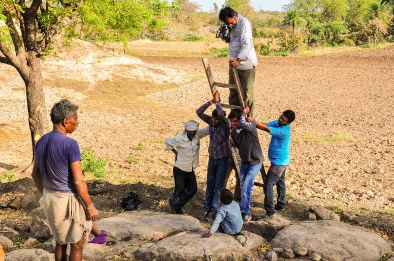 Villagers in India's Madhya Pradesh helping a palaeontologist photograph a nest of fossilised dinosaur eggs. Vishal Verma/dpa