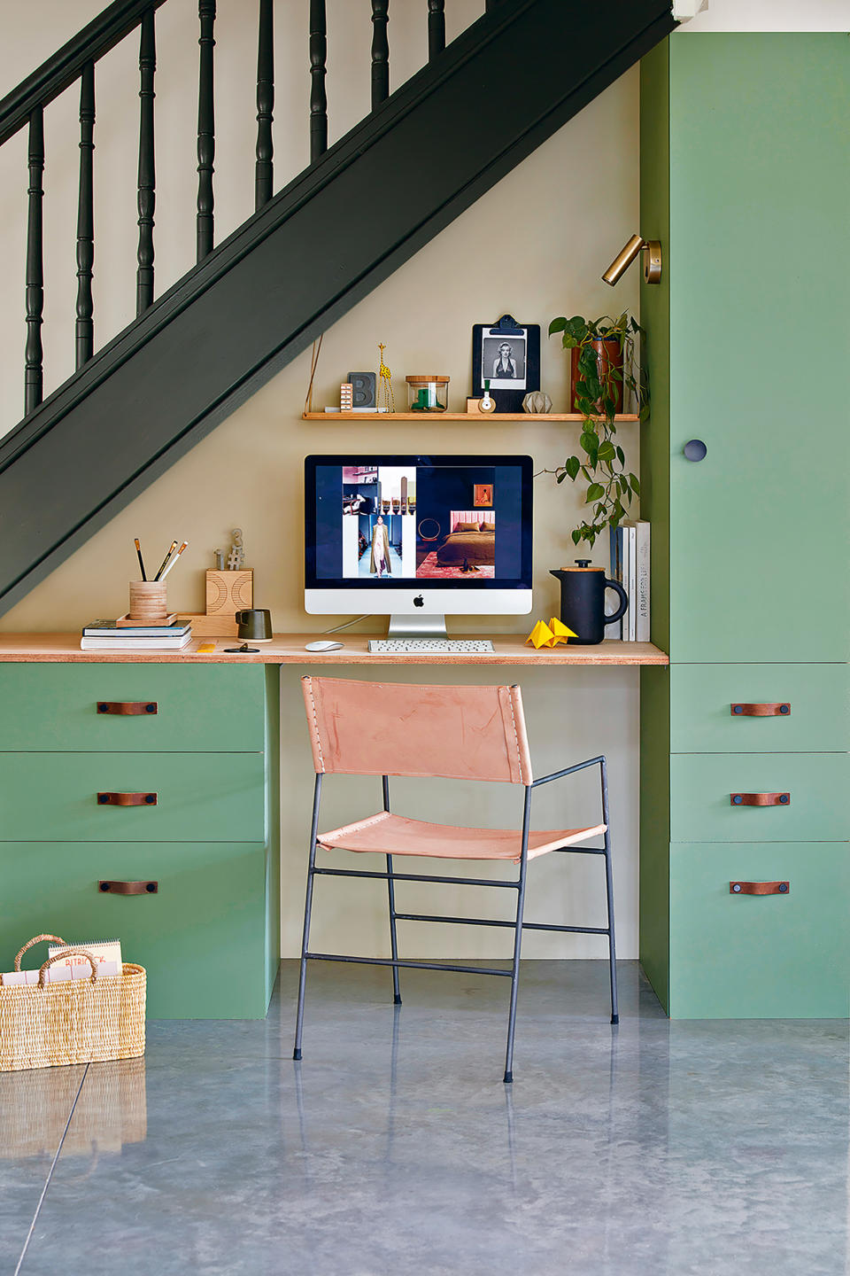 home office built in green cabinetry under the stairs with desk and laptop