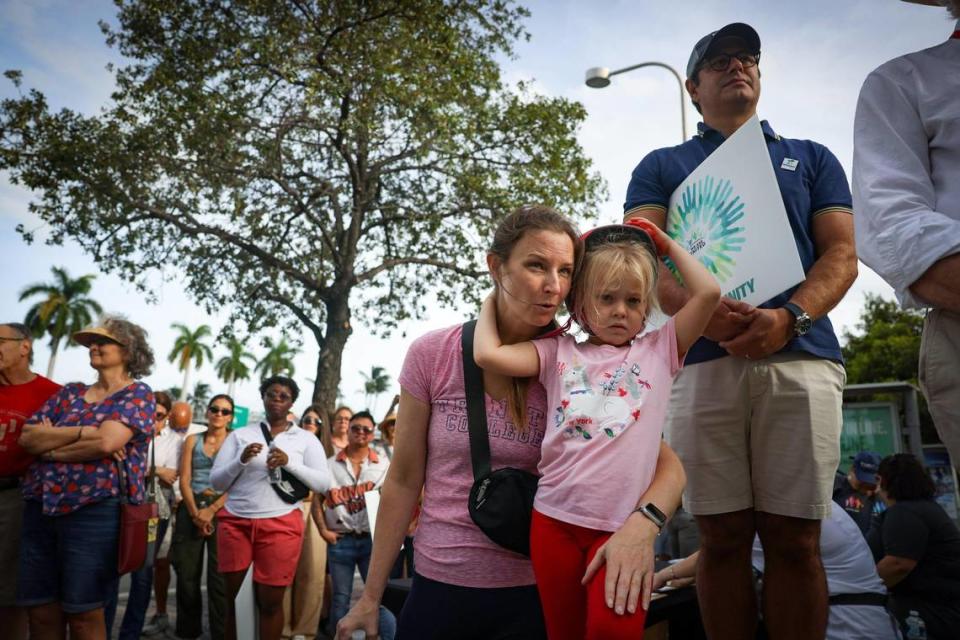 Jenny Carson (al centro) explicándole a su hija Maureen, de cinco años, qué es un imán en la marcha Estamos Unidos el domingo 5 de noviembre de 2023, en la Torre de la Libertad de Miami. "En la fe islámica, es como nuestro pastor", dijo Carson.