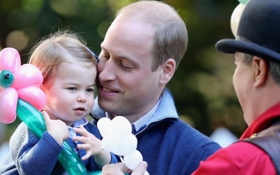 Princess Charlotte with her father, the Duke of Cambridge, at a children's party last year - Credit: Getty