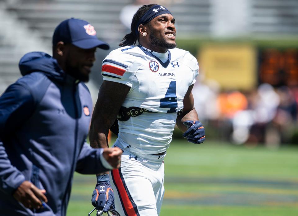 Auburn Tigers running backs coach Carnell Williams and Auburn Tigers running back Tank Bigsby (4) run off the field following warm ups during the A-Day spring practice at Jordan-Hare Stadium in Auburn, Ala., on Saturday, April 9, 2022. 