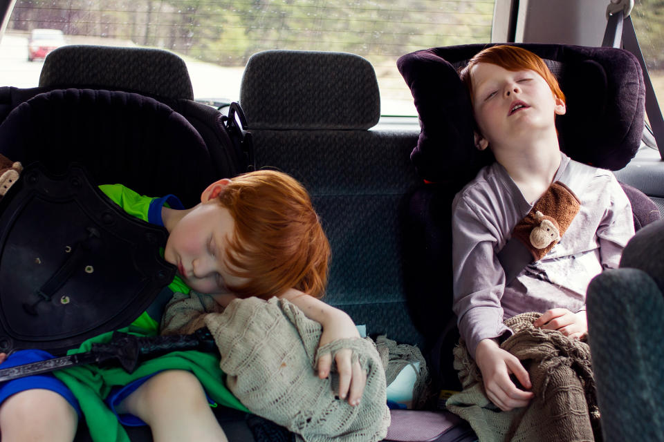 Two boys sleeping in the car