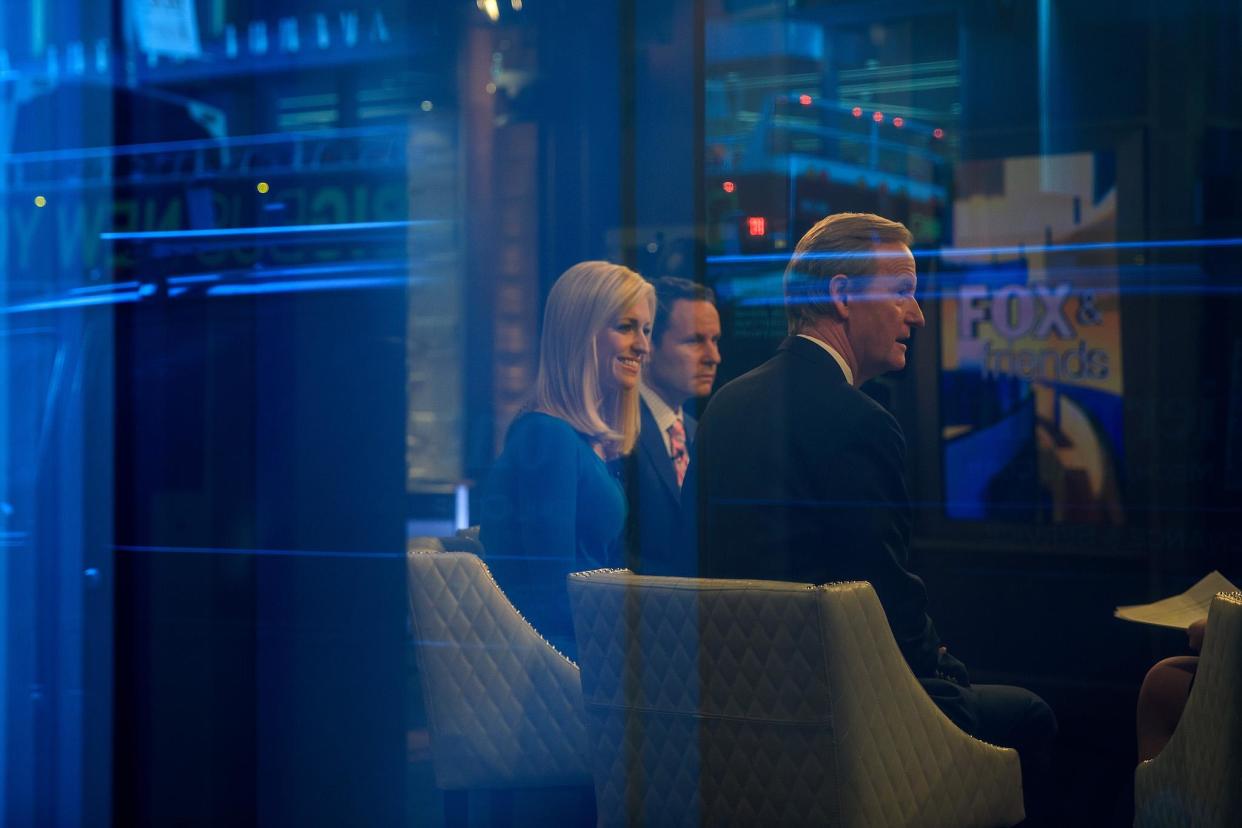 Seen through a window, hosts Brian Kilmeade, Ainsley Earhardt, and Steve Doocy broadcast 'Fox And Friends' from the Fox News studios: Getty Images