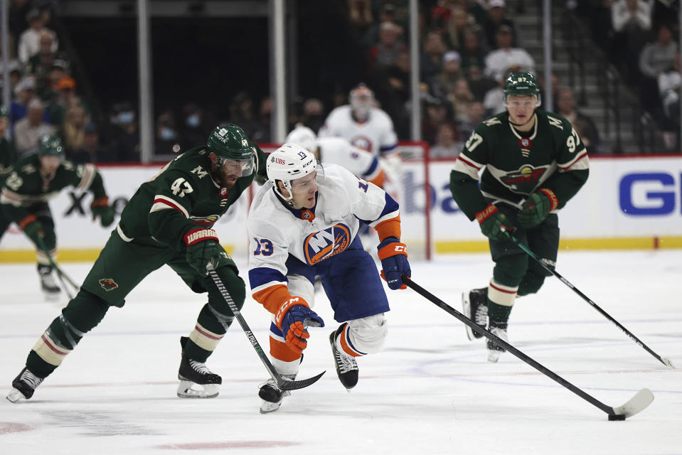 New York Islanders' Mathew Barzal (13) controls the puck against Minnesota Wild's Alex Goligoski (47) during the second period of an NHL hockey game Sunday, Nov. 7, 2021, in St. Paul, Minn. (AP Photo/Stacy Bengs)