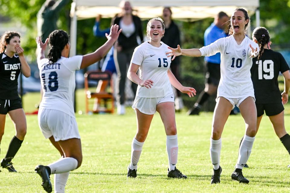 Haslett's Maddie Fant, left, celebrates her goal with teammates Lilly Meka, center, and Audrey Archambault during the second half in the game against South Lyon East on Thursday, June 9, 2022, at Fenton High School.
