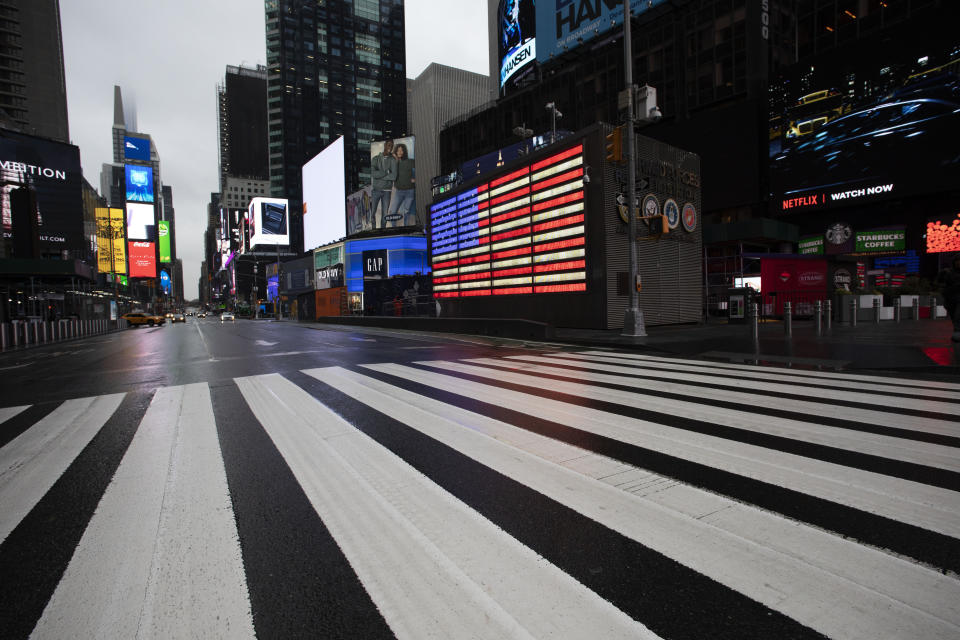 Times Square, which is usually very crowded on a weekday morning, is mostly empty Monday, March 23, 2020 in New York. Gov. Andrew Cuomo has ordered most New Yorkers to stay home from work to slow the coronavirus pandemic. (AP Photo/Mark Lennihan)