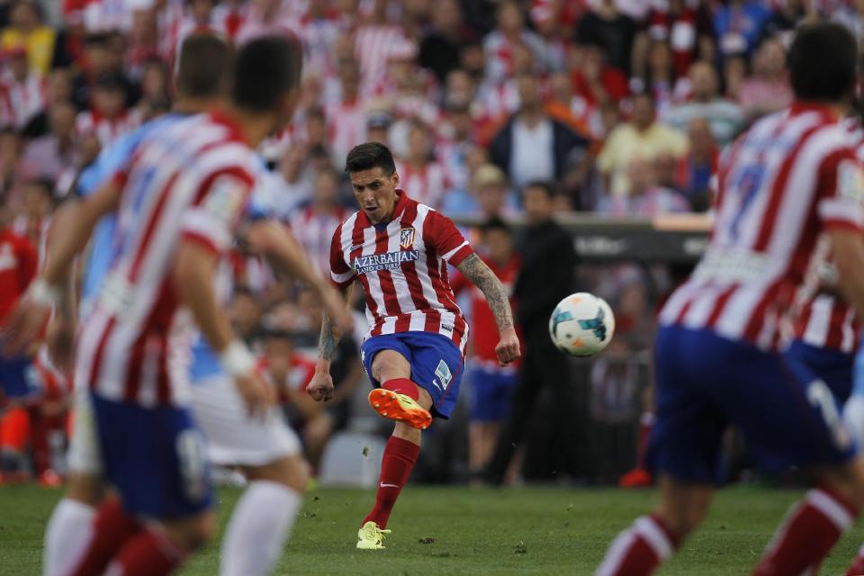 Atletico's Jose Sosa, centre, takes a shot on goal during a Spanish La Liga soccer match between Atletico Madrid and Malaga at the Vicente Calderon stadium in Madrid, Spain, Sunday May 11, 2014. (AP Photo/Gabriel Pecot)