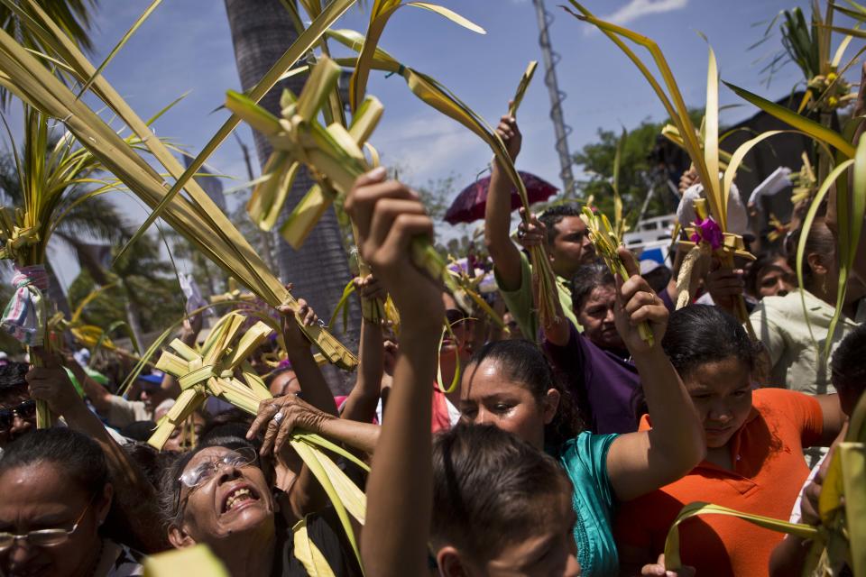 People hold up palm fronds during a Palm Sunday procession outside the Metropolitan Cathedral in Managua, Nicaragua, Sunday, April 13, 2014. For Christians, Palm Sunday marks Jesus Christ's entrance into Jerusalem, when his followers laid palm branches in his path, prior to his crucifixion. (AP Photo/Esteban Felix)