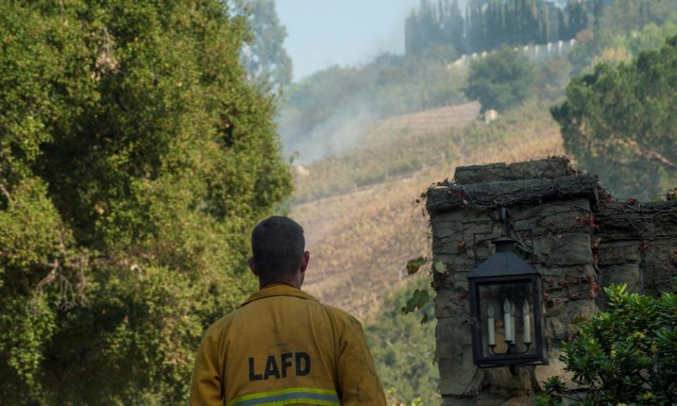 A firefighter stands outside a vineyard owned by Rupert Murdoch. The estate has been evacuated, though the house appeared undamaged. 