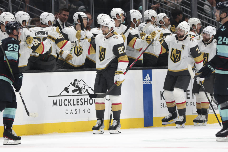 Vegas Golden Knights defenseman Shea Theodore (27) is congratulated for his goal during the second period of the team's NHL hockey game against the Seattle Kraken, Saturday, Oct. 15, 2022, in Seattle. (AP Photo/Jason Redmond)