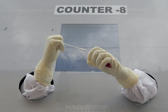 A health worker prepares to collect nasal swab samples for Covid-19 tests at a mobile testing site in Hyderabad, India (Mahesh Kumar A/AP)