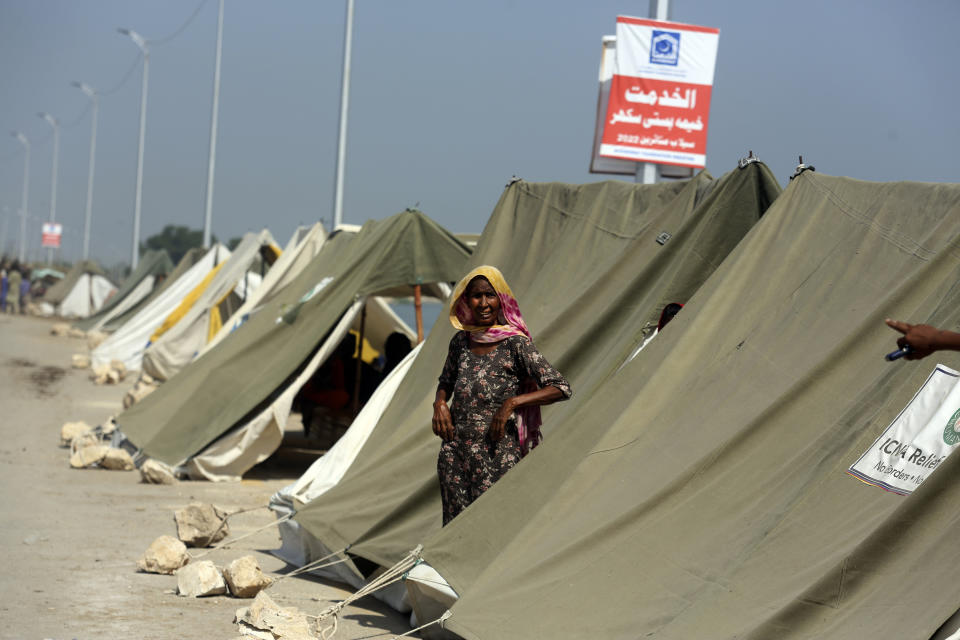 An affected woman takes refuge in a tent area after her home was hit by floods in Sukkur, Pakistan, Sunday, Sept. 4, 2022. Officials warned Sunday that more flooding was expected as Lake Manchar in southern Pakistan swelled from monsoon rains that began in mid-June and have killed nearly 1,300 people. (AP Photo/Fareed Khan)