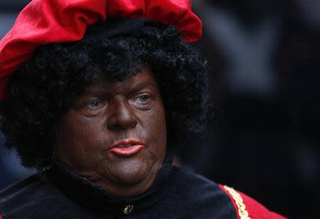 A woman dressed as "Zwarte Piet" (Black Pete), the helper of Saint Nicholas, attends a traditional parade in central Brussels in this December 1, 2012 file photo. REUTERS/Francois Lenoir/Files