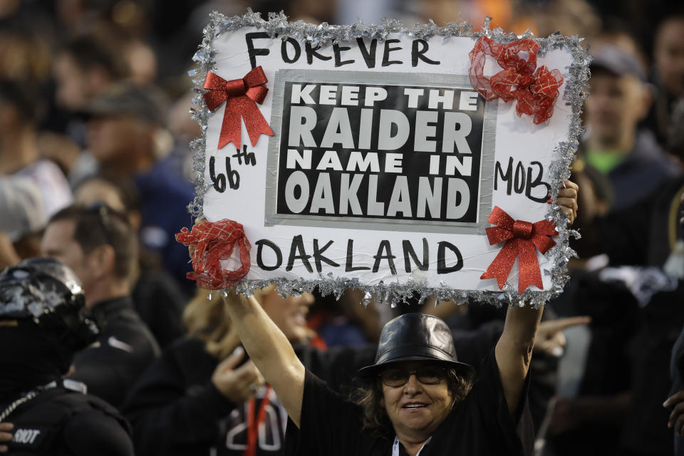 A fan holds up a sign during the first half of an NFL football game between the Oakland Raiders and the Denver Broncos Monday, Sept. 9, 2019, in Oakland, Calif. (AP Photo/Ben Margot)